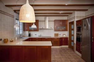 a large kitchen with wooden cabinets and a light fixture at Casa Del Nene in Navarrés