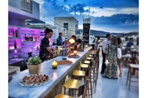 a group of people standing at a bar with food at Livadia Seaside Studios 13 in Parikia