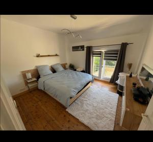 a bedroom with a bed and a large window at Maison 2chambres dressing bureau jardin clos pour 4 Personnes in Saint-Pol-de-Léon