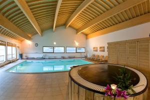 a swimming pool in a large room with a ceiling at Appartement spa fleures d'Orelle in Orelle