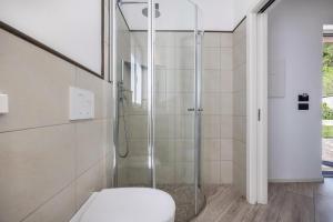 a bathroom with a glass shower with a toilet at Appartamenti Gaggiolo 2 in Dro