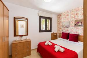 a bedroom with a bed with red sheets and a red blanket at Finca Can Lluc in Alaró +19 photos