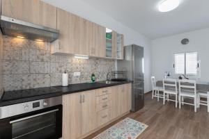 a kitchen with wooden cabinets and a stainless steel refrigerator at Casa Otilia in Arafo