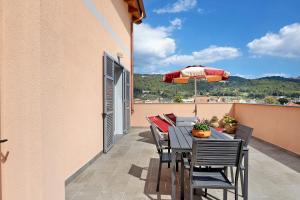 einen Tisch und Stühle auf einem Balkon mit Sonnenschirm in der Unterkunft Antichi Ricordi - Le Giare in Molino Nuovo