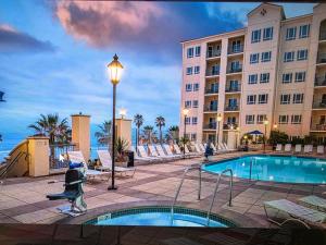 a hotel with a swimming pool in front of a building at Club Wyndham Oceanside Pier in Oceanside