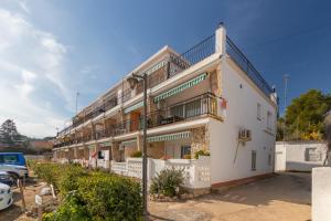 a white building with balconies and a street light at Bella mar in L'Escala
