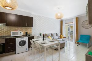 Una cocina y una sala de estar con una mesa y un sofá. en Apartamento T2 Rio E Mar, en Vila Real de Santo António 15 fotos más