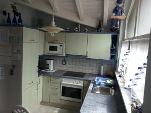 a small kitchen with white cabinets and a sink at Fewo Singler in Hofstetten
