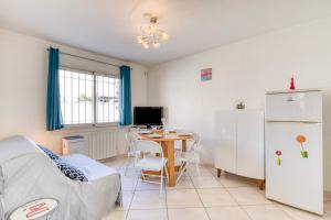 a living room with a table and a refrigerator at Le cocoon à 30m de la plage in Palavas-les-Flots
