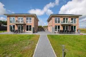 a large brick building with chairs and a patio at Ferienhaus Ebbe in Schülp