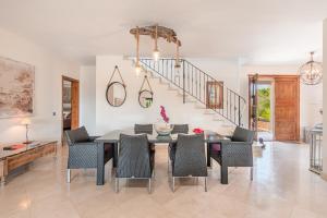 a dining room with a table and chairs and a staircase at Eco Villa Na Clavet in Alquería Blanca