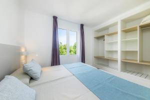 a bedroom with a large bed and a window at Apartament Massanet 2a in Canyamel