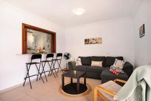 een woonkamer met een bank en een tafel bij Ático Los Seres in Los Cristianos