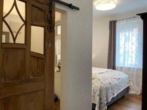 ミュンジンゲンにあるFerienwohnung Luiseのベッドルーム1室(ドア、ベッド、窓付) +4枚の写真