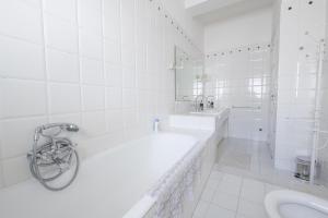 a white bathroom with a tub and a sink at Treviso 4 in Reggio Calabria