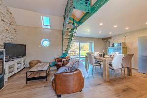 a kitchen and living room with a table and chairs at Longère de charme - jardin et spa in Plougonvelin