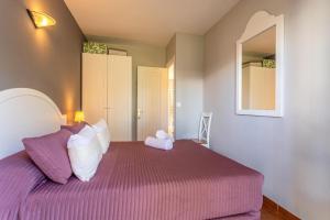 a bedroom with a large bed with purple sheets and a mirror at Villa Seve in Cala'n Bosch