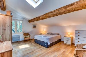 ein Schlafzimmer mit einem Bett und einem Holzboden in der Unterkunft Moun Mas in Cournonsec + 27 Fotos