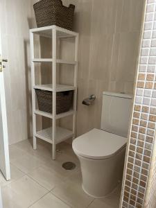 a bathroom with a white toilet and shelves at Studio 1 - Sea front in Rincón de la Victoria +17 photos