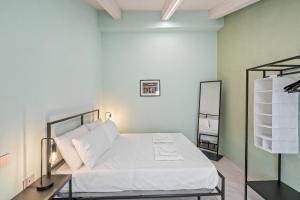 une chambre avec un lit avec des draps blancs et un miroir dans l'établissement Residenza Borgo Antico Lucia, à Ascea