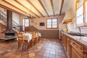 a large kitchen with a table and a fireplace at El Cup in San Martín de Tous