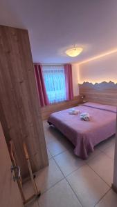 a bedroom with a purple bed and a window at Night and day 3 in Predazzo