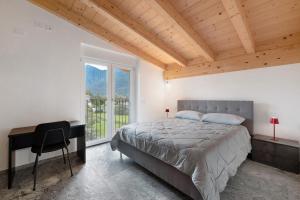 a bedroom with a bed and a desk and a window at La Villa di Ludo in San Cassiano