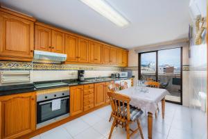 een keuken met houten kasten en een tafel met stoelen bij Atico Roger De Flor in Pollença +19 foto's