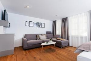 a living room with a couch and a table at Maximilian Apartments Lindau in Lindau