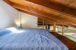 a large bed in a room with wooden ceilings at Confortevole Loft Sud Sardegna in San Giovanni Suèrgiu