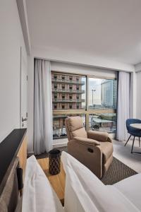 a hotel room with two chairs and a large window at The View - Saint George Hotel in Beirut