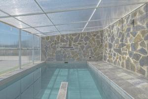 a indoor swimming pool with a stone wall at Casa El Trebol in Vejer de la Frontera