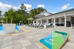 een terras met stoelen en een zwembad bij 1st Floor 3BR - Pool, Full Gym, Bikes and Grill! in Yulee