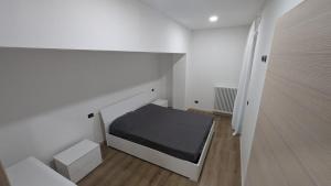 een kleine witte kamer met een bed erin bij Casa Nicla in Colico