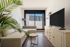 a living room with a tv and a couch at Sunset- Spa and Bbq in Calafell