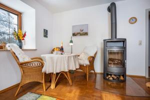 a living room with a table and a wood stove at Haus Bergliebe - Breitenbergblick in Pfronten