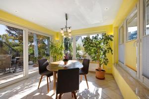 a dining room with yellow walls and a table and chairs at Cathleen Bohnert in Lindau