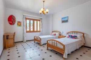 een slaapkamer met twee bedden en een raam bij Cas Cover in Santa Margalida