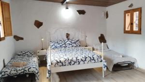 Santa Maria de GuiaにあるHogar vacacional Mayaの白い壁のベッドルーム1室(ベッド2台付)