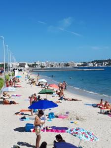 meublé tourisme 3 étoiles vue mer في جولف جيون: زحمة الناس على شاطئ فيه مظلات