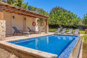 une piscine avec des chaises et une maison dans l'établissement Son Del Rio Nou, à Pollença