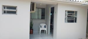 ein weißer Stuhl, der im Türrahmen eines Hauses steht in der Unterkunft Casa na Praia da Cal - Torres in Torres