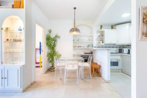 een keuken met witte kasten en een tafel en stoelen bij Costa Lago Playa in Torremolinos