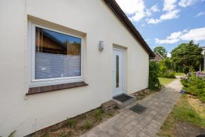 a white house with a window and a sidewalk at Ferienwohnung Immenhof in Schwienau