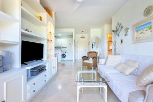 een woonkamer met een witte bank en een tv bij Costa Lago Playa in Torremolinos