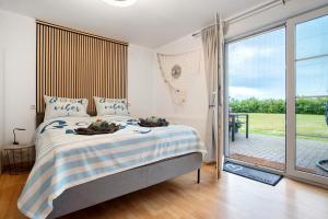 リーブニッツ・ダムガルテンにあるFerienwohnung Lütte Veerのベッドとガラスの引き戸のある寝室