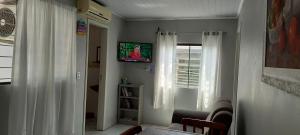 ein Wohnzimmer mit einem Fernseher an der Wand in der Unterkunft Casa na Praia da Cal - Torres in Torres