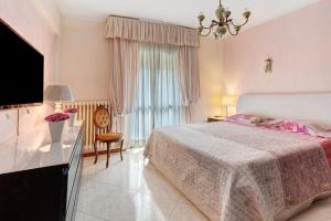 シルミオーネにあるLa Terrazza Appartamento Agataのベッドとテーブルとテレビのある寝室