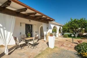 a patio with a table and chairs and a house at Villa Mavi in Quartucciu