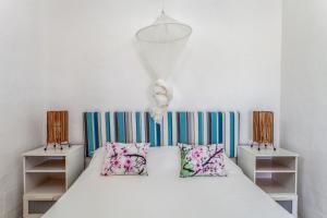 a bedroom with a white bed with two pillows at Oasis en Cotillo in El Roque